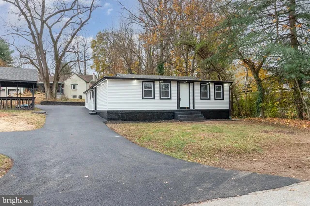a view of a house with a yard and large tree