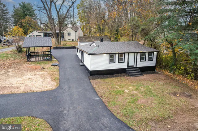 a aerial view of a house with large trees and wooden fence