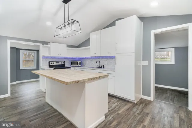 a view of kitchen with stainless steel appliances granite countertop a stove and a sink