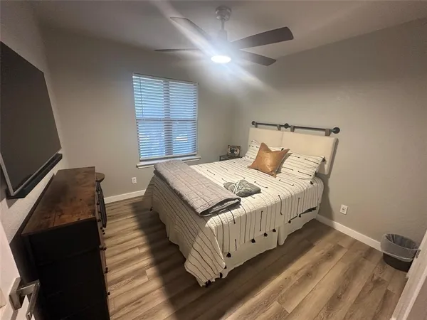 a bedroom with a bed and a flat tv screen on a dresser