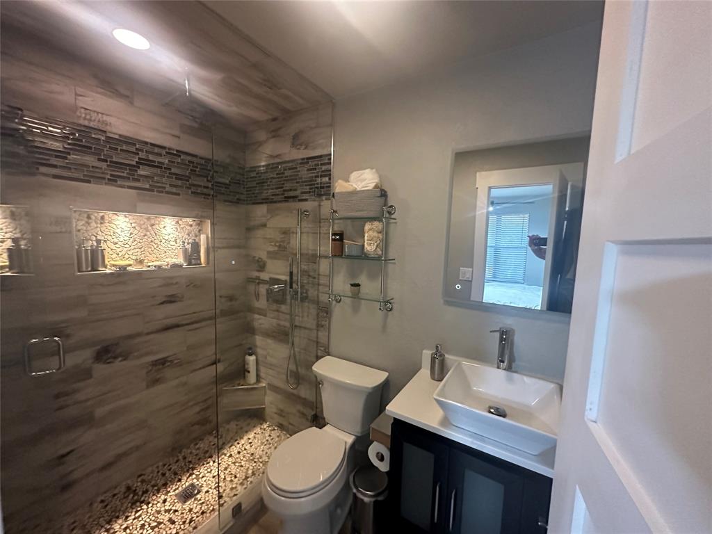 3059 Hells Gate Loop, Unit 8 Strawn, TX 76475 - Photo 15 of 20 a bathroom with a granite countertop toilet sink and mirror