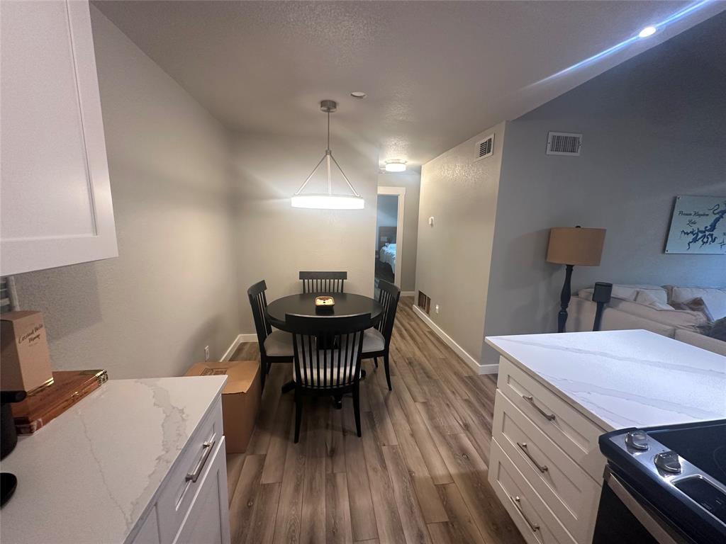 3059 Hells Gate Loop, Unit 8 Strawn, TX 76475 - Photo 8 of 20 a view of a dining room with furniture and wooden floor
