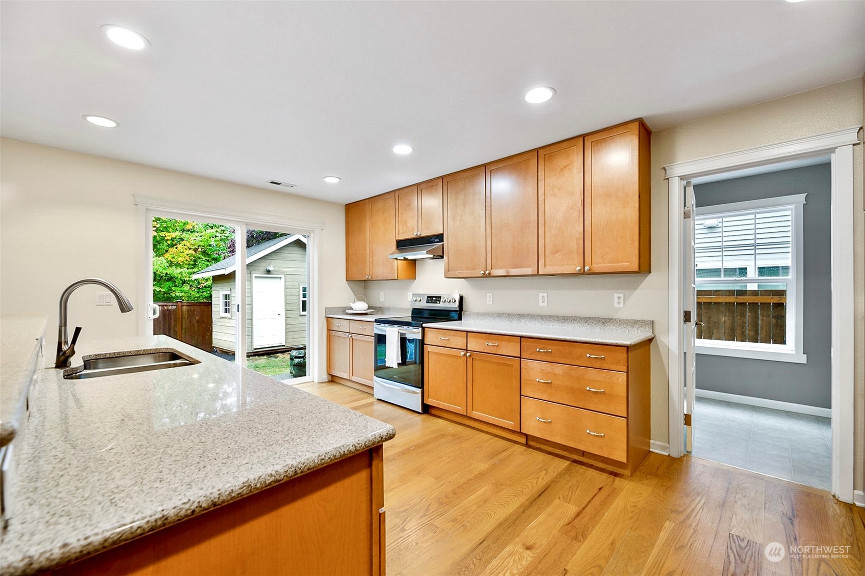 20227 Rustic View Road Southeast Monroe, WA 98272 - Photo 13 of 37 a kitchen with stainless steel appliances granite countertop a sink a stove and a wooden cabinets