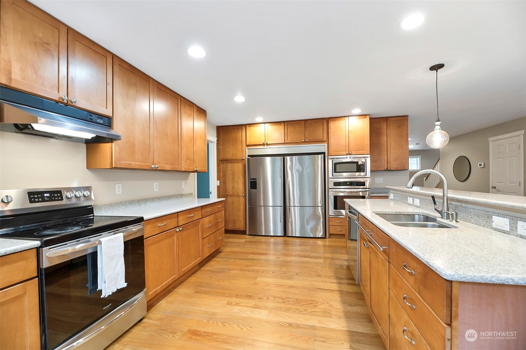 20227 Rustic View Road Southeast Monroe, WA 98272 - Photo 14 of 37 a kitchen with stainless steel appliances granite countertop a sink a stove and a wooden cabinets