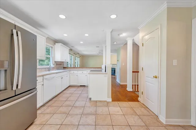 a kitchen with a refrigerator and white cabinets