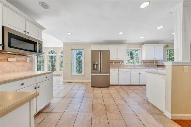 a kitchen with a refrigerator sink and cabinets
