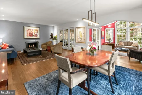 a living room with furniture a bookshelf and a large window