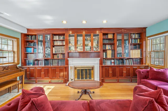 a living room with furniture a fireplace and bookshelf