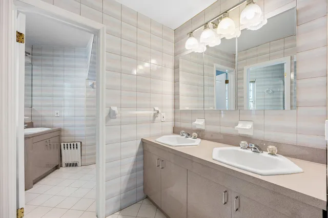 a bathroom with a double vanity sink a toilet and a mirror