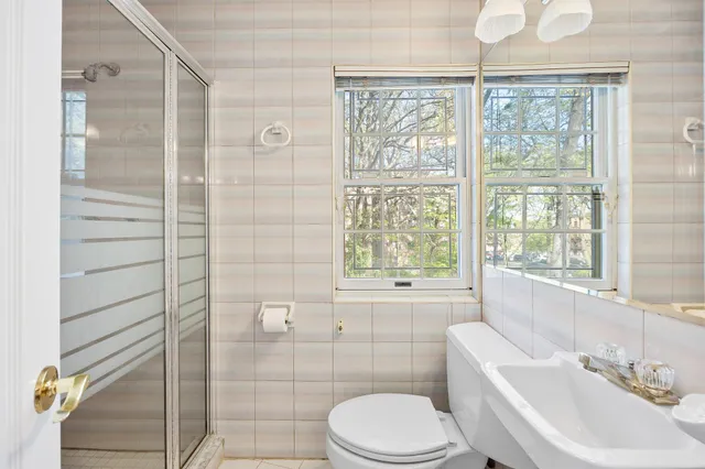 a bathroom with a sink a toilet and shower