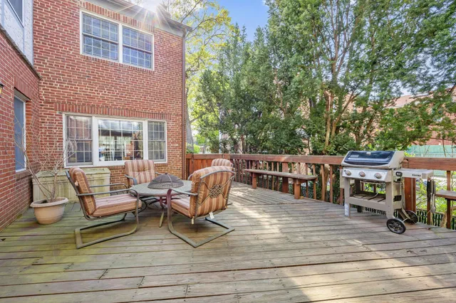 a view of a deck with table and chairs barbeque with wooden floor and fence