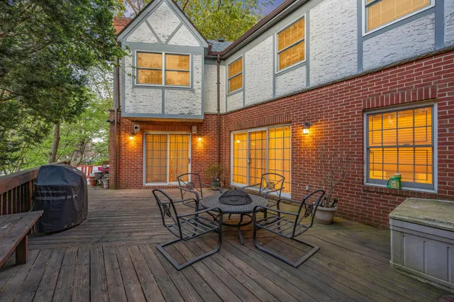 a view of a patio with table and chairs with wooden floor and fence
