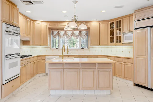 a kitchen with a sink window and cabinets