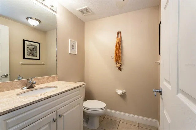 a bathroom with a granite countertop toilet sink and mirror