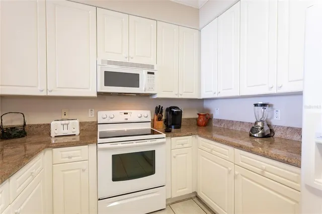a kitchen with white cabinets and white appliances