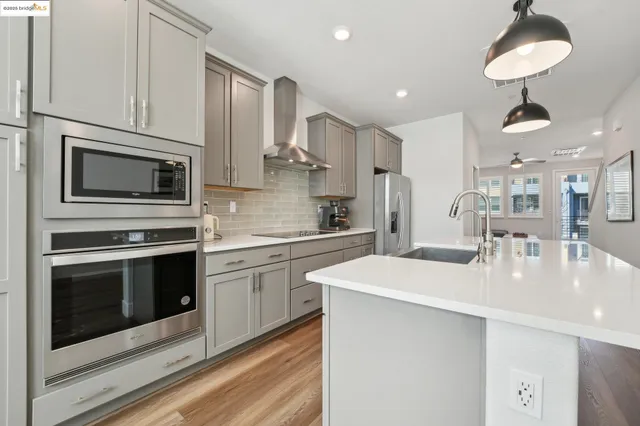 a kitchen with stainless steel appliances a sink a stove and cabinets