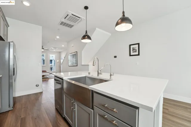 a kitchen with kitchen island a stove a sink and wooden floor
