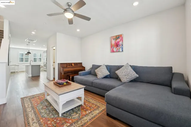 a living room with furniture and a view of kitchen