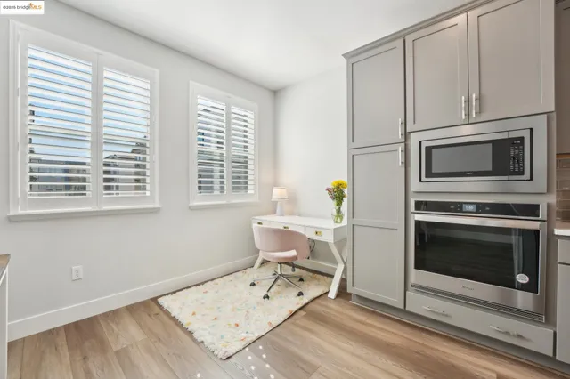 a kitchen with stainless steel appliances granite countertop a stove top oven a sink dishwasher a dining table and chairs with wooden floor