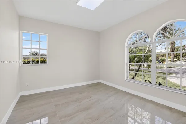a view of an empty room with closet and a window