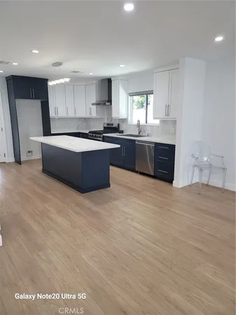 a large kitchen with stainless steel appliances granite countertop a large counter top a sink and dishwasher
