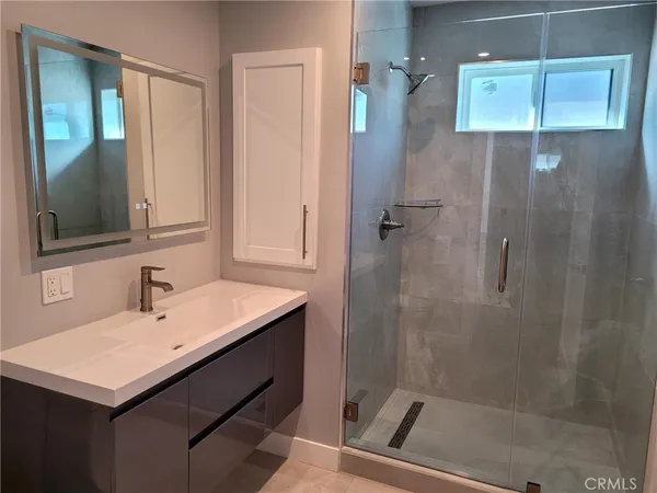 a bathroom with a sink a mirror and shower