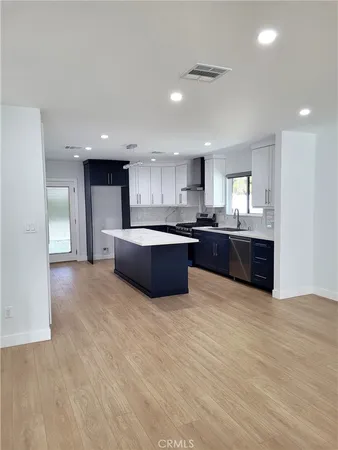 a large kitchen with stainless steel appliances granite countertop a large counter top and a stove top oven