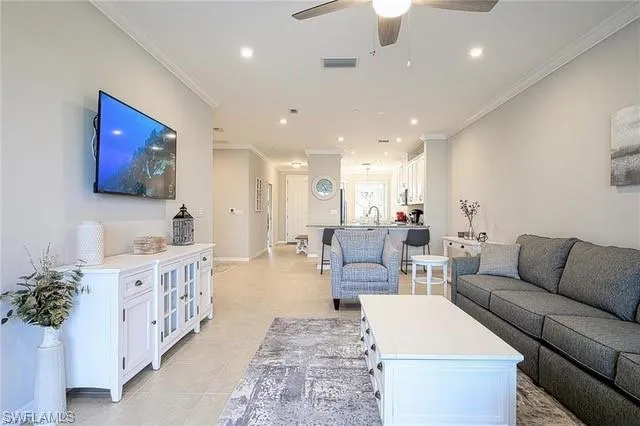 a living room with furniture kitchen view and a large window
