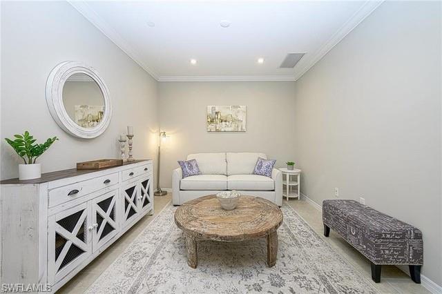 9365 Pocida Court, Unit 102 Naples, FL 34119 - Photo 14 of 38 a living room with furniture and a dresser