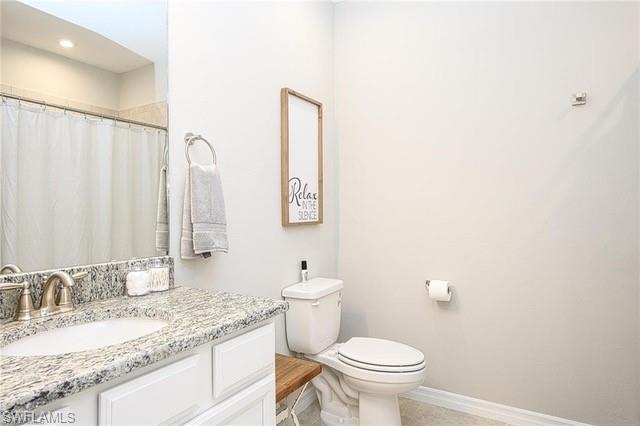 9365 Pocida Court, Unit 102 Naples, FL 34119 - Photo 19 of 38 a bathroom with a granite countertop sink a toilet and a mirror