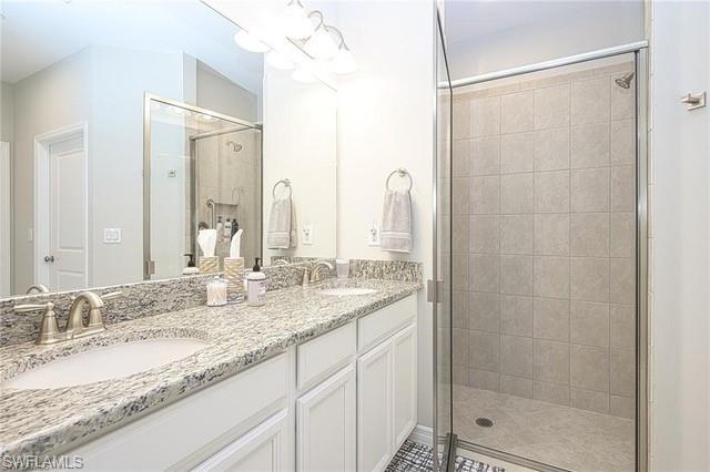 9365 Pocida Court, Unit 102 Naples, FL 34119 - Photo 22 of 38 a bathroom with a granite countertop sink and a mirror