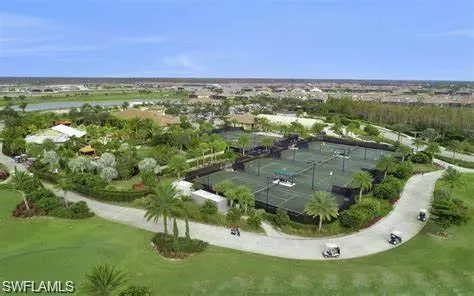 an aerial view of residential houses with outdoor space and trees