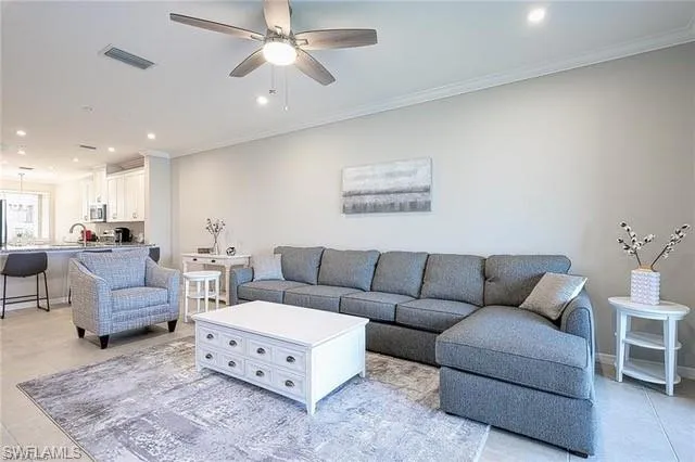 a living room with furniture ceiling fan and a rug