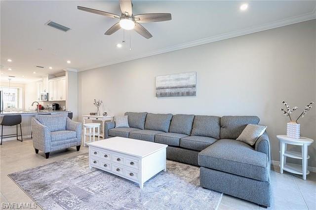 9365 Pocida Court, Unit 102 Naples, FL 34119 - Photo 10 of 38 a living room with furniture ceiling fan and a rug