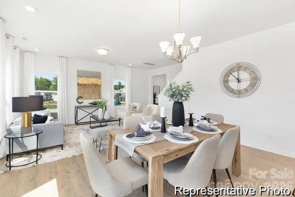 a view of a dining room with furniture a chandelier and wooden floor