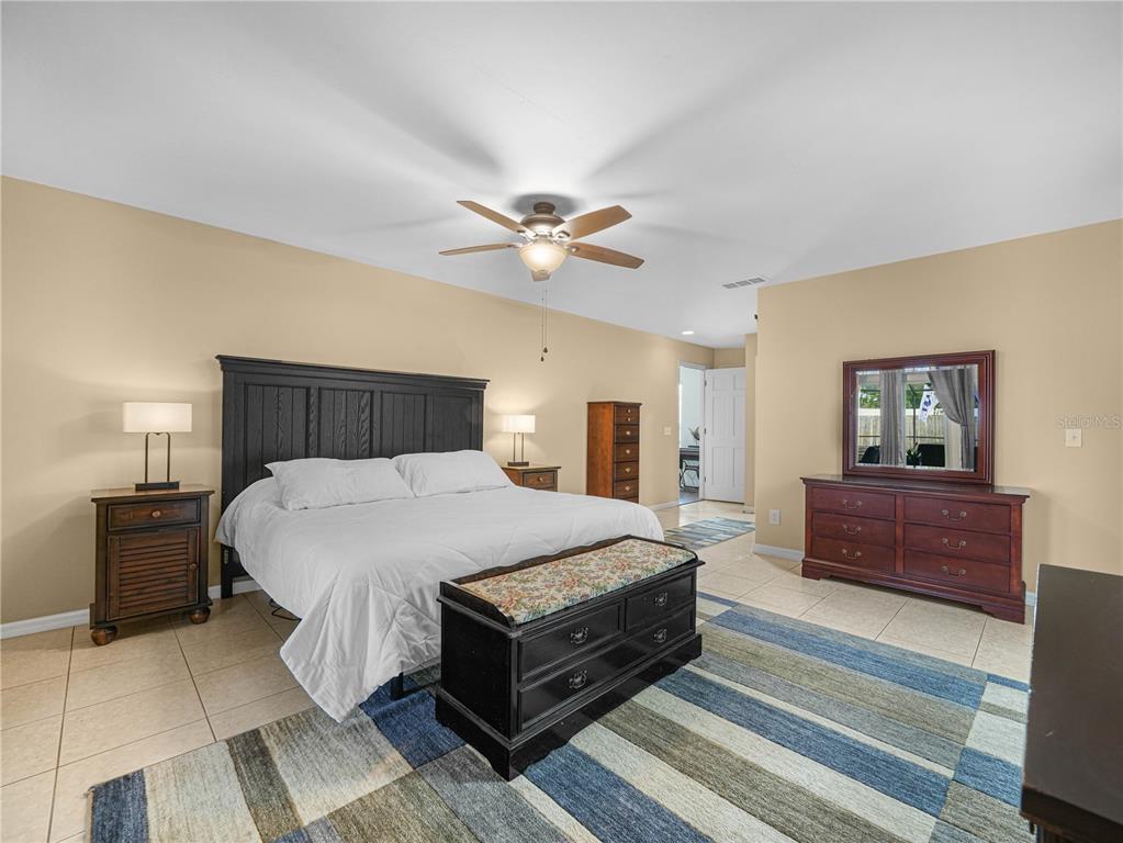 4615 Kings Point Court Lakeland, FL 33813 - Photo 15 of 41 a bedroom with a large bed and a chandelier