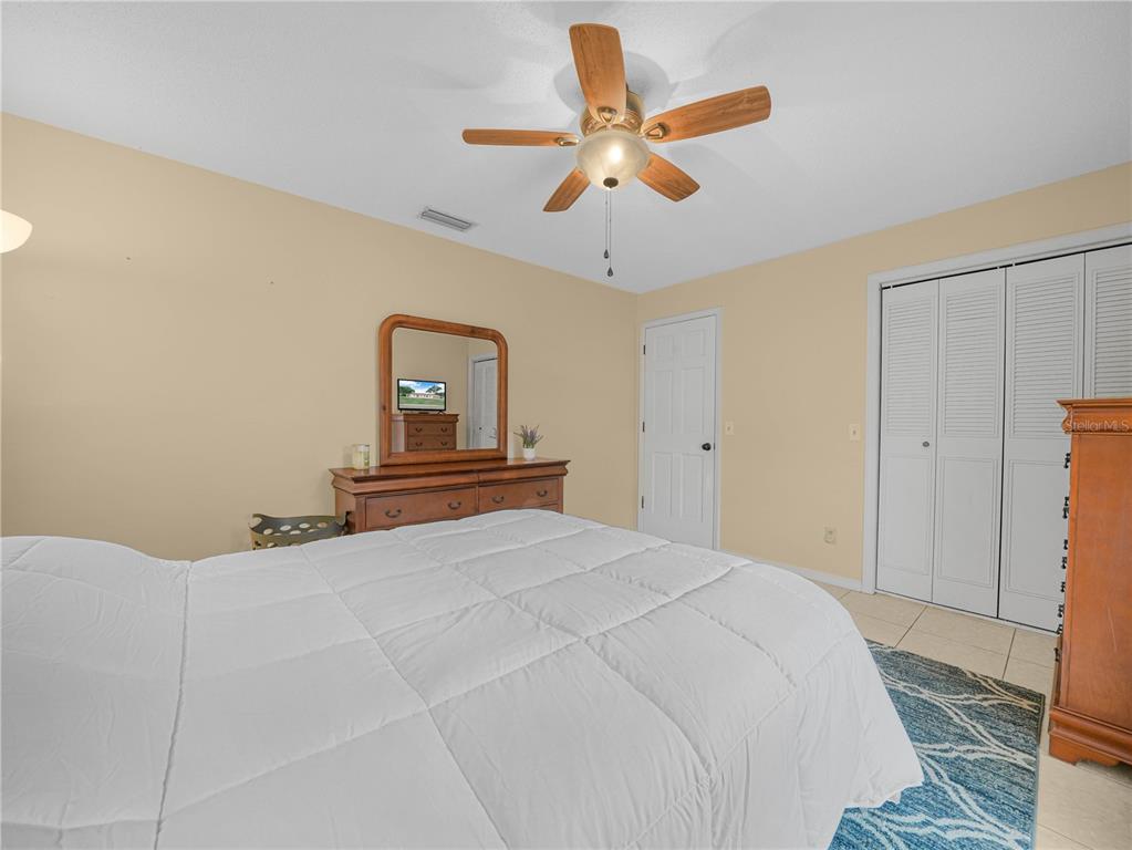 4615 Kings Point Court Lakeland, FL 33813 - Photo 22 of 41 a bedroom with a large bed and a chandelier