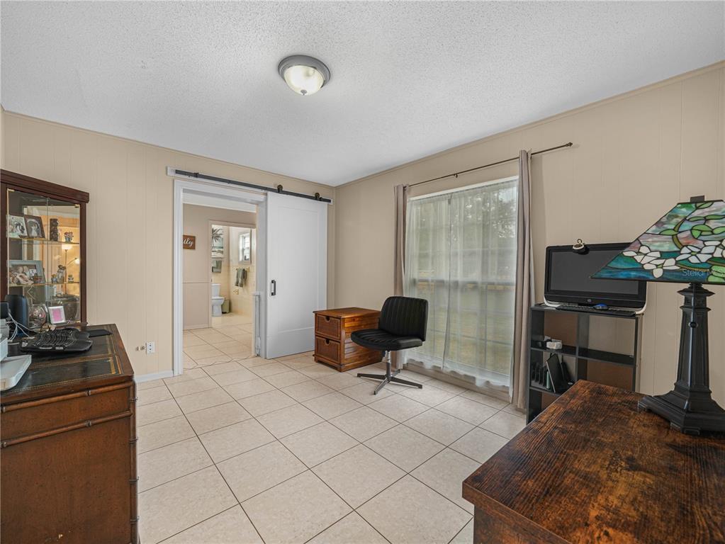 4615 Kings Point Court Lakeland, FL 33813 - Photo 25 of 41 a living room with furniture a flat screen tv and a refrigerator