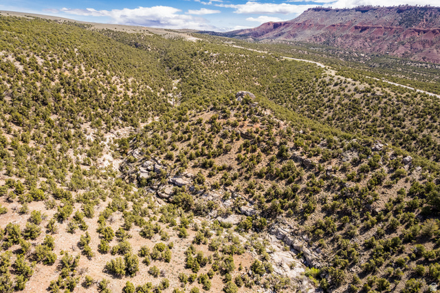2650 Taylor Mountain Road, Unit REMARK Vernal, UT 84078 - Photo 6 of 7 Expansive natural landscape featuring varied terrain, abundant low-lying vegetation, rock formations, and distant red rock formations