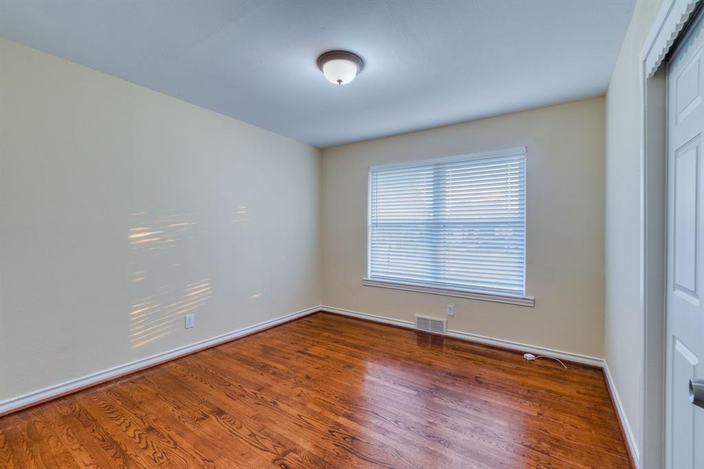 314 Easton Road Dallas, TX 75218 - Photo 12 of 26 an empty room with wooden floor and windows