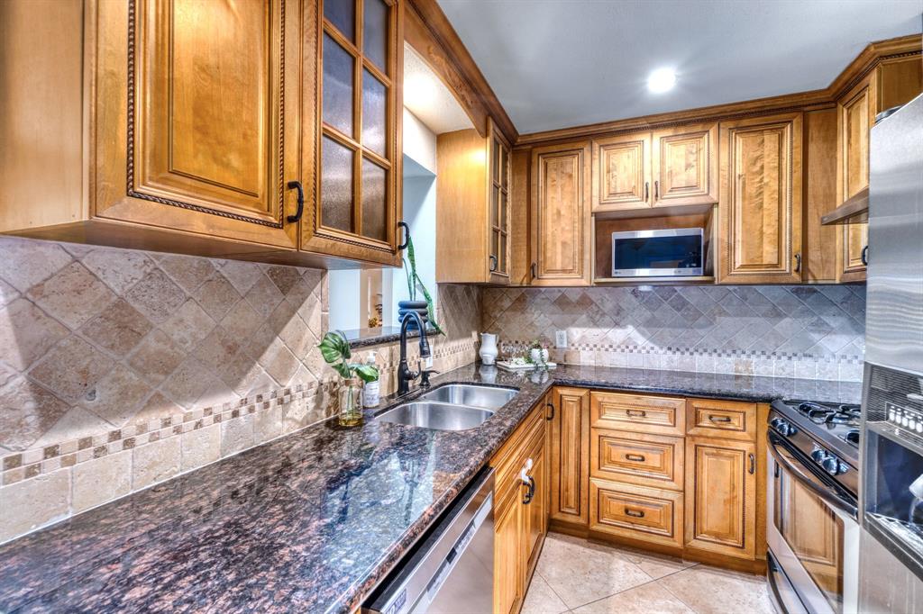 314 Easton Road Dallas, TX 75218 - Photo 20 of 26 a kitchen with granite countertop a stove a sink and a microwave