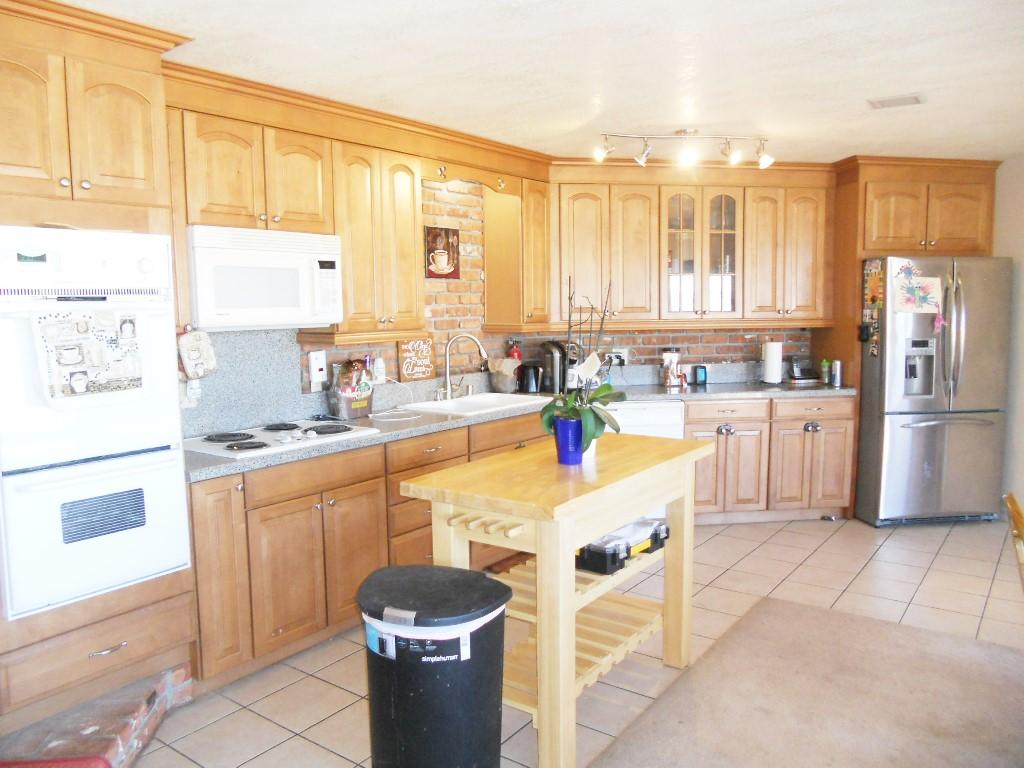 22712 Mariposa Road Tehachapi, CA 93561 - Photo 3 of 21 a large kitchen with kitchen island granite countertop a stove a sink a dining table and chairs