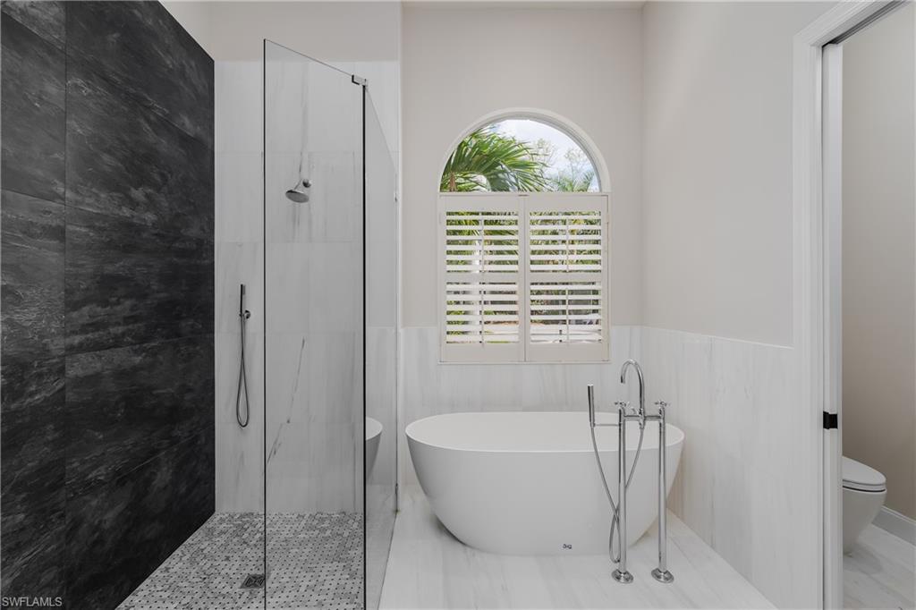 2280 Hawks Ridge Loop Naples, FL 34105 - Photo 21 of 33 Bathroom featuring tile walls and plus walk in shower