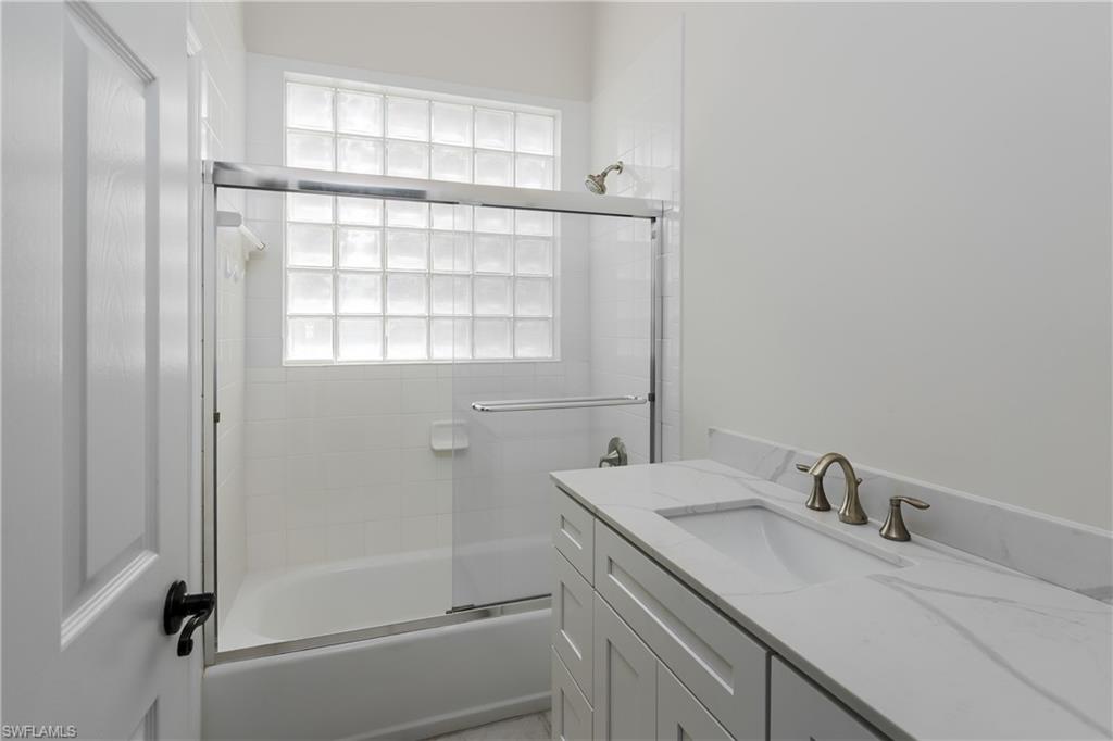 2280 Hawks Ridge Loop Naples, FL 34105 - Photo 25 of 33 Bathroom with vanity and bath / shower combo with glass door