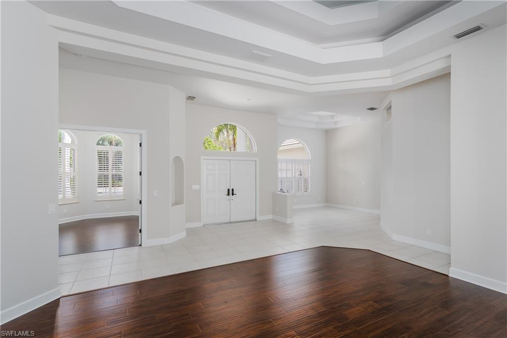 2280 Hawks Ridge Loop Naples, FL 34105 - Photo 5 of 33 Entryway with a towering ceiling, a raised ceiling, and light hardwood / wood-style floors