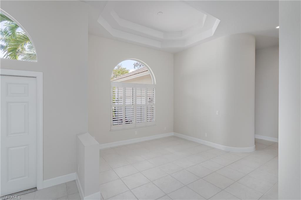 2280 Hawks Ridge Loop Naples, FL 34105 - Photo 7 of 33 Tiled empty room featuring a raised ceiling