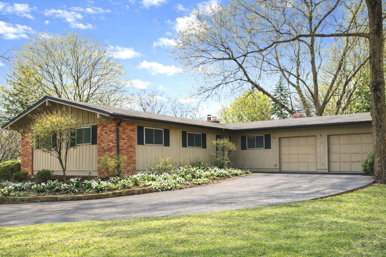 a front view of house with yard and trees around