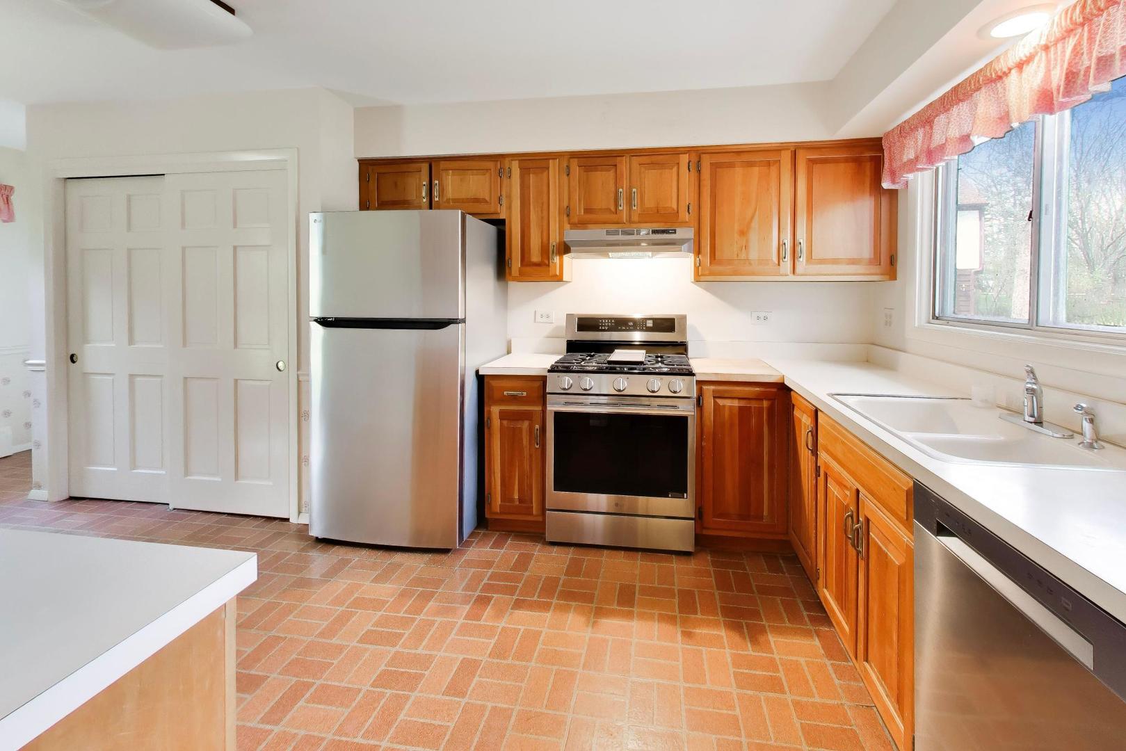 1056 Van Tassel Road Sleepy Hollow, IL 60118 - Photo 6 of 34 a kitchen with stainless steel appliances granite countertop a stove a sink and a refrigerator