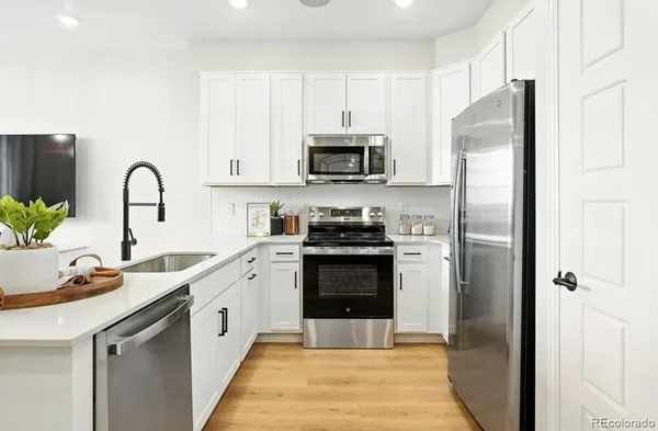 a kitchen with stainless steel appliances granite countertop a sink stove and microwave