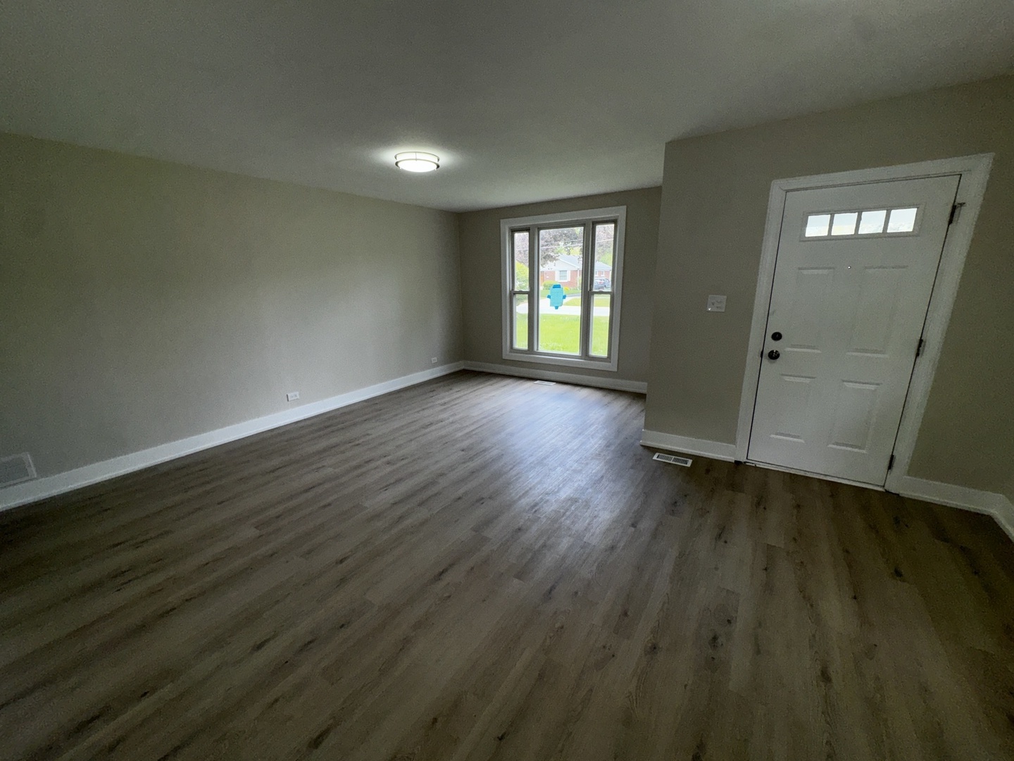 722 East Indiana Street Wheaton, IL 60187 - Photo 3 of 10 a view of an empty room with wooden floor and a window